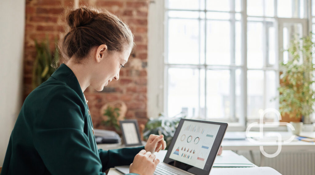 Businesswoman looking at charts on computer screen