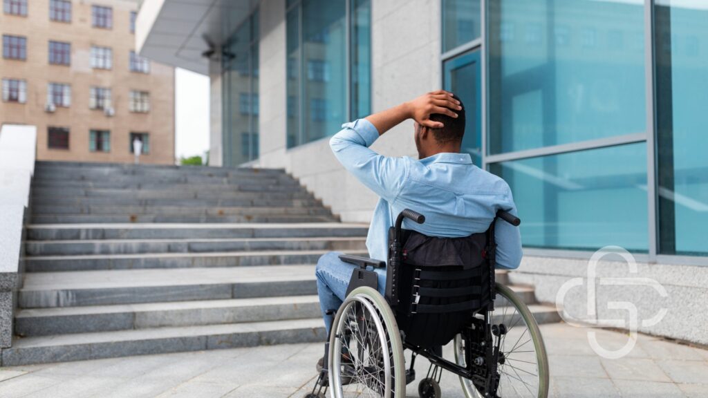 Man in a wheelchair looking at stairs unable to access building